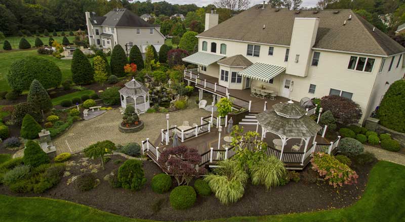 Backyard landscape design with gazebos, ornamental shrubs, and fall garden plantings in New Jersey.