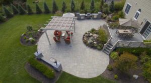 Spacious backyard patio with pergola, outdoor kitchen, and multiple dining areas designed for entertaining.