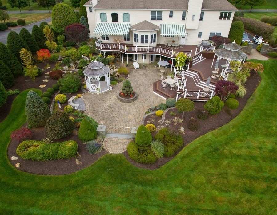 Aerial view of landscaped yard with patio, gazebo, and gardens