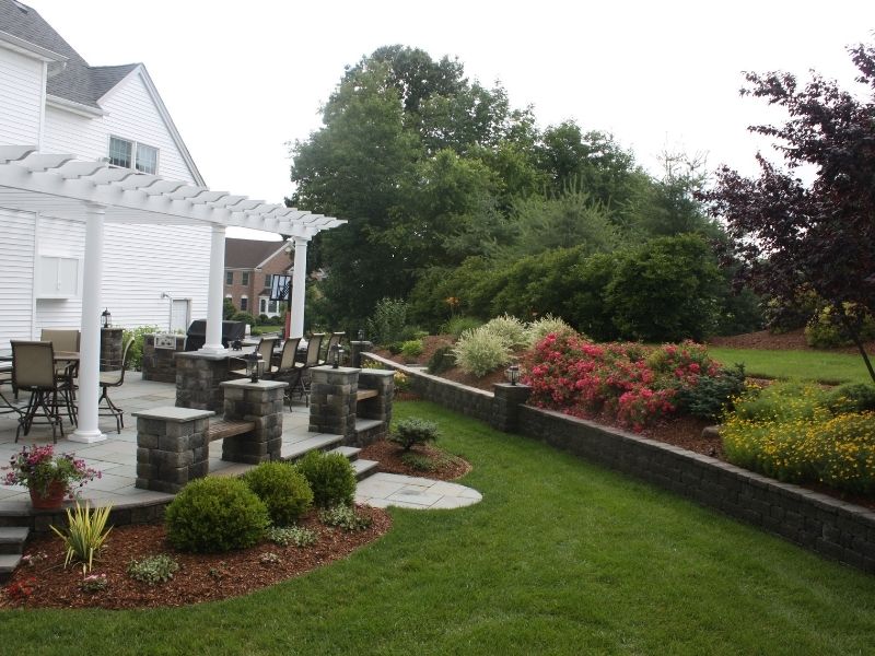 Stone walkway with shrubs around a suburban house