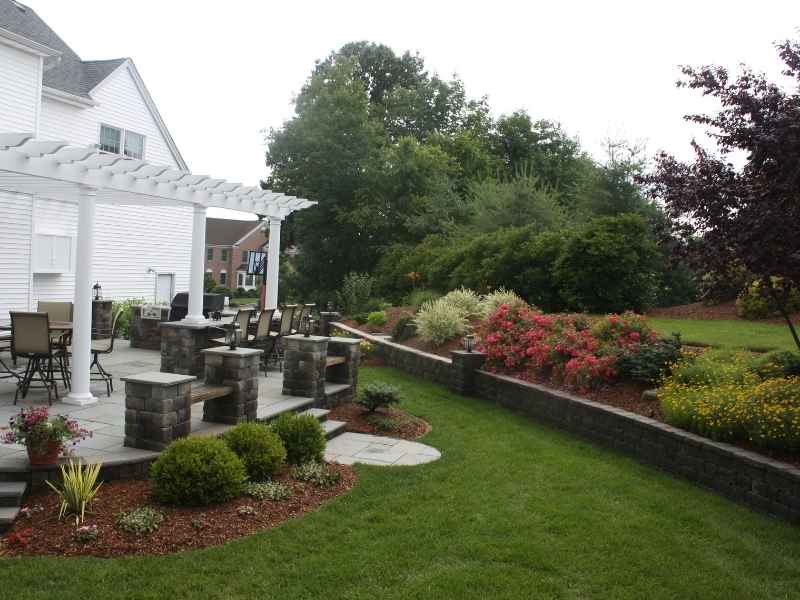 Stone walkway with shrubs around a suburban house