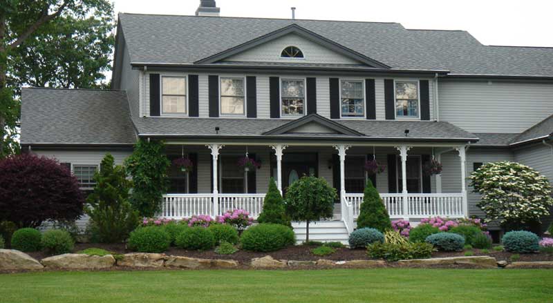 Front yard landscape design featuring flowering shrubs, manicured garden beds, and ornamental evergreens to enhance curb appeal at a Morris County, NJ home.